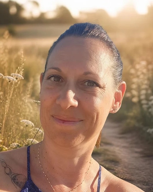 Portrait d’Orlane, souriante, dans un champ au soleil couchant