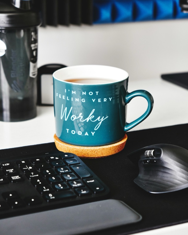 Une tasse de thé posée près du clavier, prête pour la visio